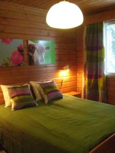 um quarto com uma grande cama verde com almofadas em Loma-Rantala Cottages em Tahkovuori