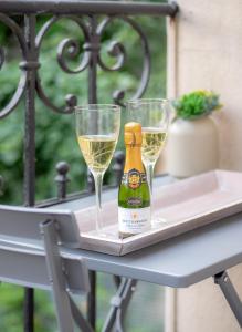 a bottle of champagne and two glasses on a table at City Apartments Siegburg Studios in Siegburg