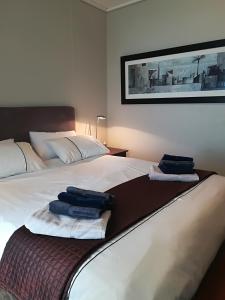 a bedroom with a bed with two towels on it at A310 Lagoon Beach Apartment & Spa in Cape Town +15 photos