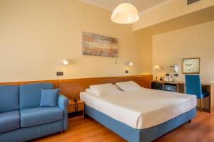 a bedroom with a bed and a blue couch at Best Western Hotel Globus in Rome