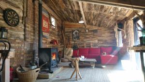 a living room with a red couch and a fireplace at La Cabane Aux Loups in Crépy-en-Valois