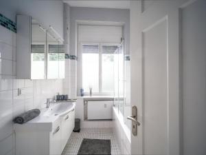a white bathroom with a sink and a window at City Apartments Siegburg in Siegburg +21 photos