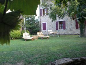three chairs sitting in the grass in front of a building at Agriturismo Campo del Pillo in Pietradura