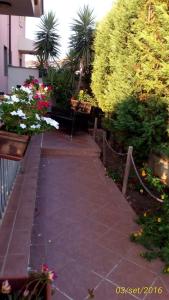 una pasarela en un jardín con bancos y flores en Taverna Paradiso, en Acquedolci