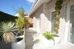 a courtyard with potted plants on the side of a house at La villa Mauricia in Lacanau-Océan