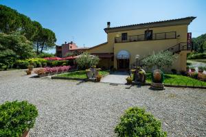 a house with a gravel driveway in front of it at Hotel Molino D'Era in Volterra