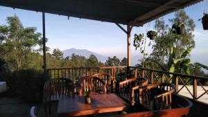 a wooden table and chairs on a balcony with a view at Bromo Tanjung in Tosari