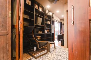 a chair in a room with a wall of shelves at Narra House Sukhumvit58 in Bangkok