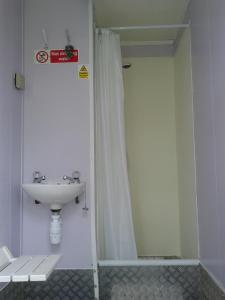 een badkamer met een wastafel en een douchegordijn bij The Valley Bell Tents, Bring Your Own Bedding in Amroth