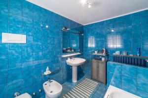 bagno piastrellato blu con lavandino e servizi igienici di Bed and Breakfast Miotto a Montegalda Altre 35 foto