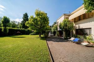 un cortile con un edificio e un prato con sedie di Bed and Breakfast Miotto a Montegalda