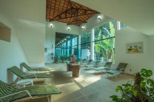 a lobby with chairs and a table and windows at Hotel Estância Atibainha - Resort & Convention in Nazaré Paulista