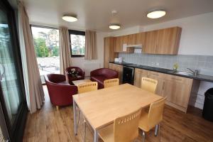 una cocina con mesa y sillas de madera en Perth Youth Hostel and Apartments, en Perth