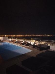 a swimming pool at night with a view of the ocean at A310 Lagoon Beach Apartment & Spa in Cape Town