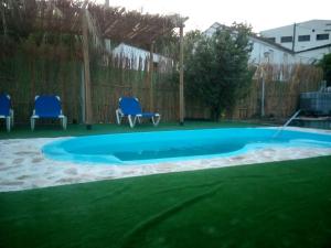 a swimming pool in a yard with two chairs at Alojamiento rural El Batán in Priego de Córdoba