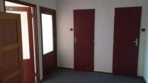 an empty room with three doors in a building at Penzión Inštitút in Košice