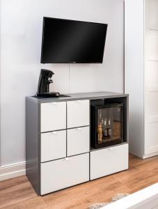 a tv on top of a white entertainment center with a fireplace at City Apartments Siegburg Studios in Siegburg
