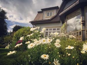 un campo de flores blancas delante de una casa en Hotel Serenade de Franz Schubert, en Frutillar