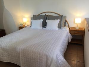 una camera da letto con un grande letto bianco con due lampade di Two Bedroom Apartment in Montepulciano a Montepulciano