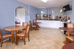 a restaurant with tables and chairs and a kitchen at Americas Best Value Inn & Suites Branson - Near The Strip in Branson