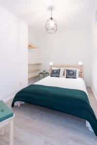 ein Schlafzimmer mit einem Bett mit einer grünen Decke in der Unterkunft Slowlife Furadouro in Furadouro