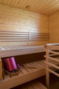 una sauna de madera con un cubo púrpura en el estante en Leenan tupa, en Sonka