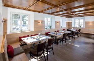 a restaurant with wooden ceilings and tables and chairs at Schloss-Gasthof Sonne in Isny im Allgäu