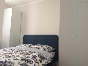 シュチェチンにあるBusiness and Relax Cukrowniaのベッドルーム1室(青いヘッドボードと枕付きのベッド1台付)