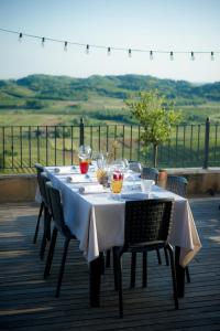 a table with chairs and wine glasses on a patio at Klinec Plešivo Art Rooms in Dobrovo