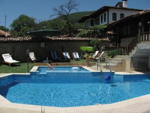 a swimming pool with two people in it at Sava Cupetsa Guest House in Zheravna