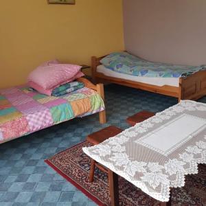 a room with two beds and a table in it at Agroturystyka Maria Dębska in Sromowce Wyżne