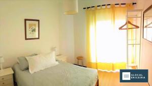 a bedroom with a bed and a window at Casa Ouriceira, Centro Ericeira in Ericeira