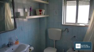 a blue tiled bathroom with a toilet and a sink at Casa Ouriceira, Centro Ericeira in Ericeira