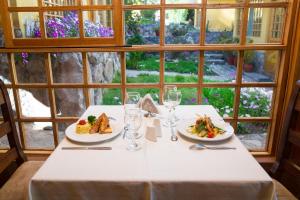Amaru Valle Hotel في أوروبامبا: طاولة بيضاء عليها طبقين من الطعام