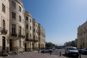 a street with cars parked in front of buildings at Sea View Maisonette by MyHolidayLet in Brighton & Hove +10 photos