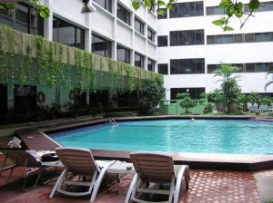 a swimming pool in front of a building at Asia Hotel Bangkok in Bangkok