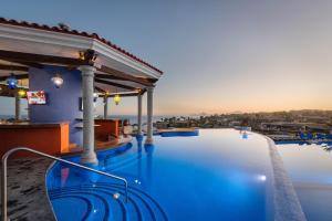 a pool at a resort with a view of the ocean at El Encanto All Inclusive Resort in Cabo San Lucas