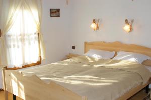 a bedroom with a wooden bed with a window at Sava Cupetsa Guest House in Zheravna +29 photos