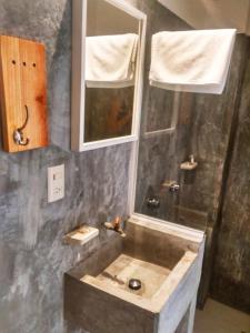 un baño con lavabo y espejo en La Tozi Hotel, en San Cristóbal de Las Casas