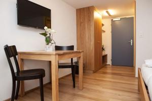 a room with a desk with a television on a wall at Gasthaus Löwen in Hemberg