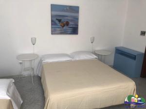 1 Schlafzimmer mit 2 Einzelbetten und 2 Tischen in der Unterkunft Blu Mare in Ponza