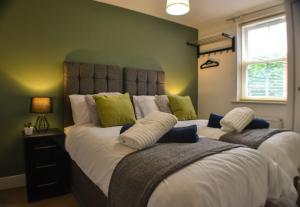 two beds in a bedroom with a green wall at St George Court, Spacious 2BR Apartments, City Centre, Self Check In, Parking, By DerBnB in Derby
