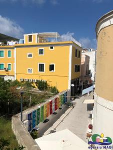 a yellow building with a fence next to a sidewalk at Blu Mare in Ponza