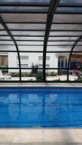 una piscina azul con un edificio de fondo en Apartamentos Turísticos Rurales Monte de las Ánimas, en Valdepeñas de Jaén