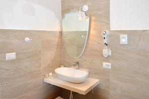 La salle de bains est pourvue d'un lavabo et d'un miroir. dans l'établissement B&B PALAZZO MARZO, à Otrante