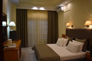 a hotel room with a bed and a window at Hotel Diamantidis in Myrina