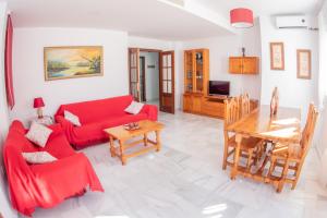 サンルーカル・デ・バラメダにあるMarelenaのリビングルーム(赤いソファ、テーブル付)