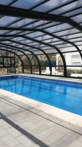 a large swimming pool with a metal roof at Apartamentos Turísticos Rurales Monte de las Ánimas in Valdepeñas de Jaén