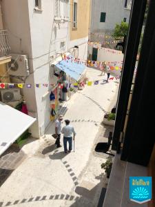 dos hombres caminando por una calle estrecha con banderas en Blu Mare, en Ponza
