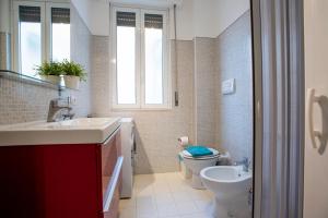 a bathroom with a sink and a toilet and a window at DELPOSTO Marina di Ragusa (lp) in Marina di Ragusa